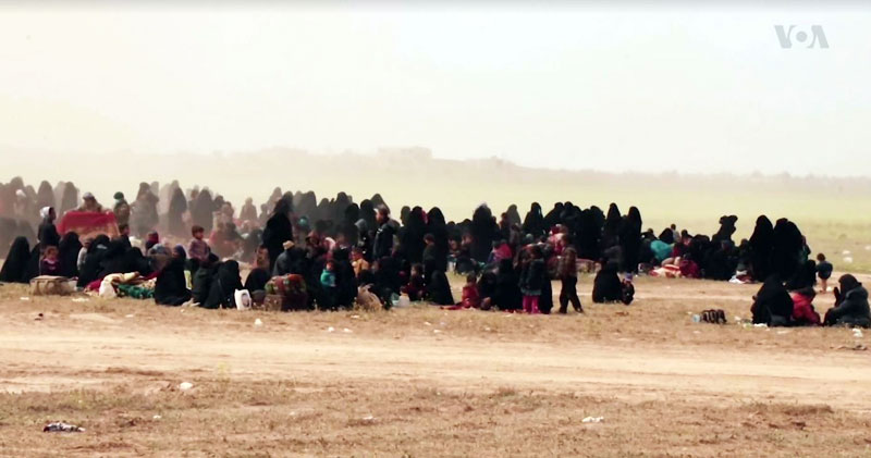 Des familles de combattants de l’État Islamique (Daech) faits prisonniers par les Forces Démocratiques Syriennes en Syrie de l’est (8 mars 2019). Source : https://www.voanews.com/a/more-is-wives-flee-syria-s-baghuz/4821141.html ; Wikimedia commons)