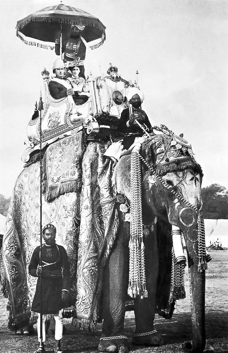 « Le Gouverneur général de l’Inde George Curzon et son épouse Mary Curzon sur le dos de l’éléphant ‘Lakshman Prasad’ à Delhi, le 29 décembre 1902. » (Source : Wikimedia commons) La légende ne mentionne pas les noms des valets indigènes. « Le Gouverneur général de l’Inde George Curzon et son épouse Mary Curzon sur le dos de l’éléphant ‘Lakshman Prasad’ à Delhi, le 29 décembre 1902. » (Source : Wikimedia commons) La légende ne mentionne pas les noms des valets indigènes.