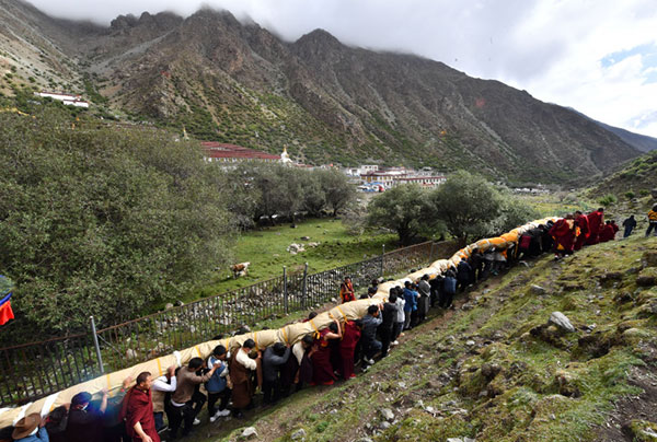Des moines et des adeptes du bouddhisme participent à un rituel annuel d'exposition de tanka de Bouddha au monastère de Tsurphu, dans la région autonome du Tibet (sud-ouest de la Chine), le 11 juin 2022