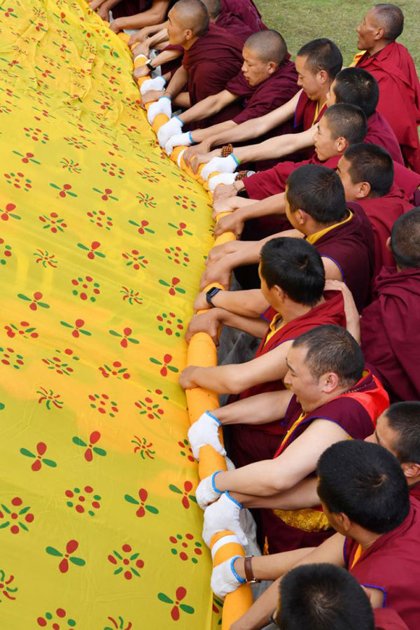 Des moines participent à un rituel annuel d'exposition de tanka de Bouddha au monastère de Tsurphu, dans la région autonome du Tibet (sud-ouest de la Chine), le 11 juin 2022
