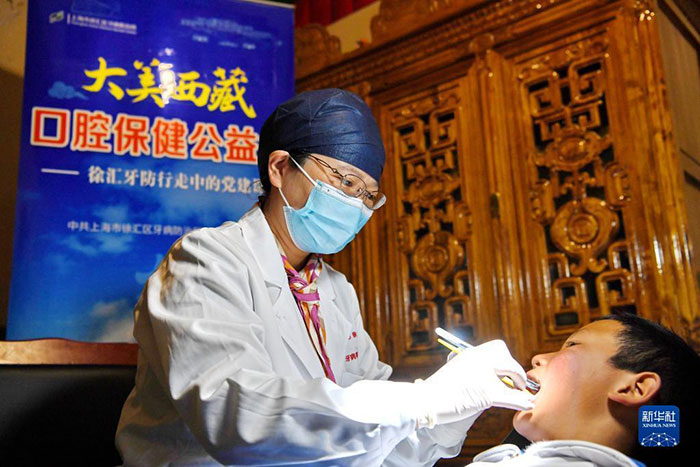 Su Hongru, docteure au Centre de prévention et de traitement des maladies dentaires du district de Xuhui, à Shanghai, est en train de soigner une carie d’un enfant au xian de Nagarzê, au Tibet, le 8 juillet 2023. (Zhang Rufeng / Xinhua)