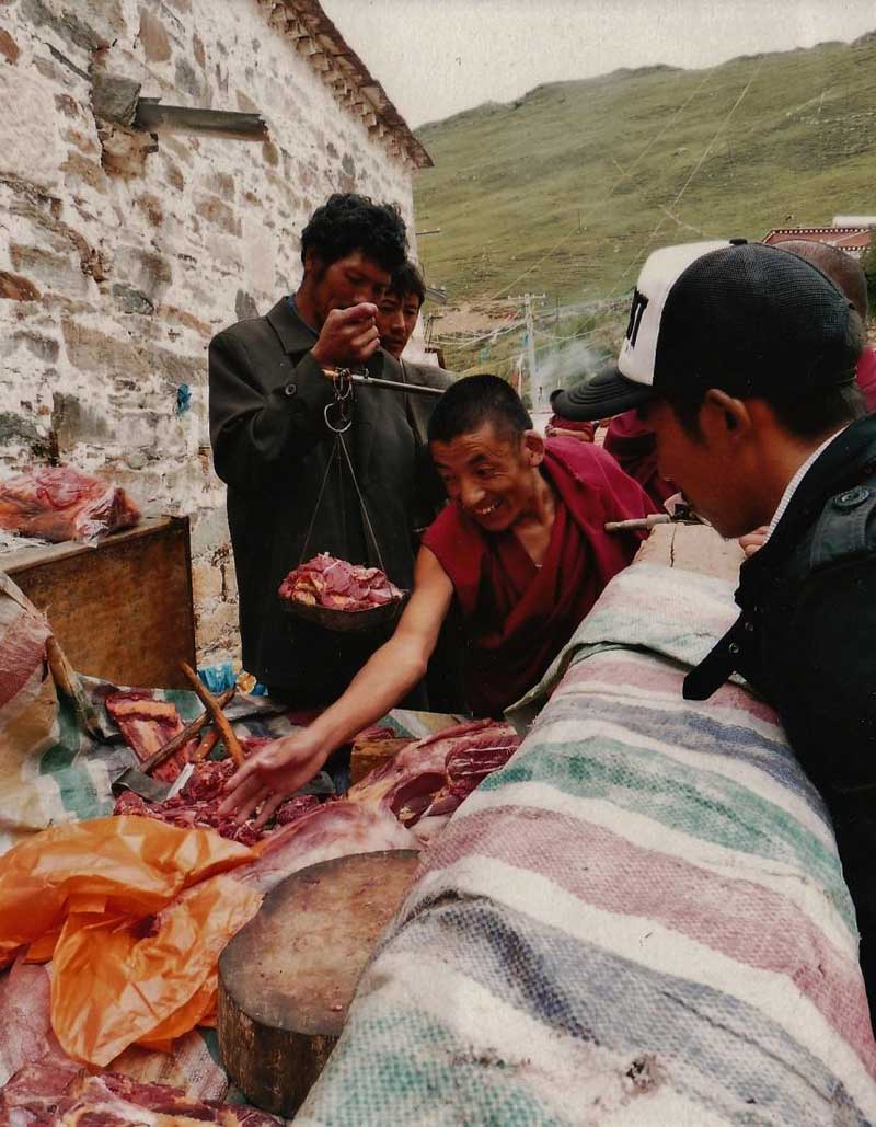 Un moine se servant de viande à Ganden, le 6 août 2009 avant de s’emporter contre la photographe, Thérèse de Ruyt