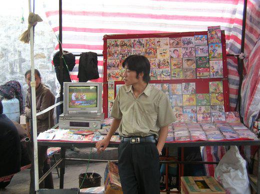 jeune Tibétain qui vend des DVD chinois et tibétains dans le centre de Lhassa (photo JPDes, 2008) jeune Tibétain qui vend des DVD chinois et tibétains dans le centre de Lhassa (photo JPDes, 2008)